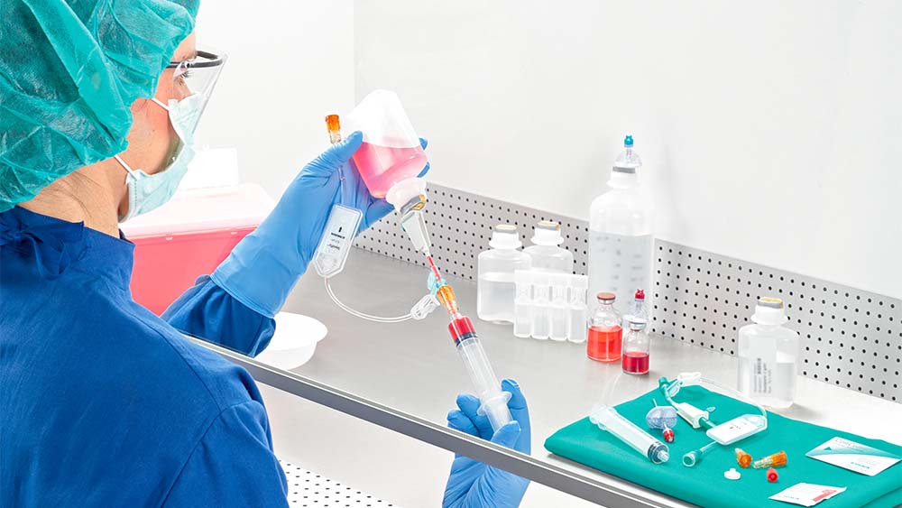 A gyógyszerész felhúzza a fecskendőt a lamina légáramlása alatt