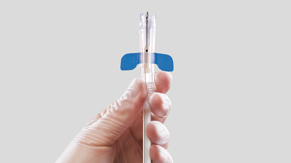 Kéz egy diacan biztonsági tűt tart