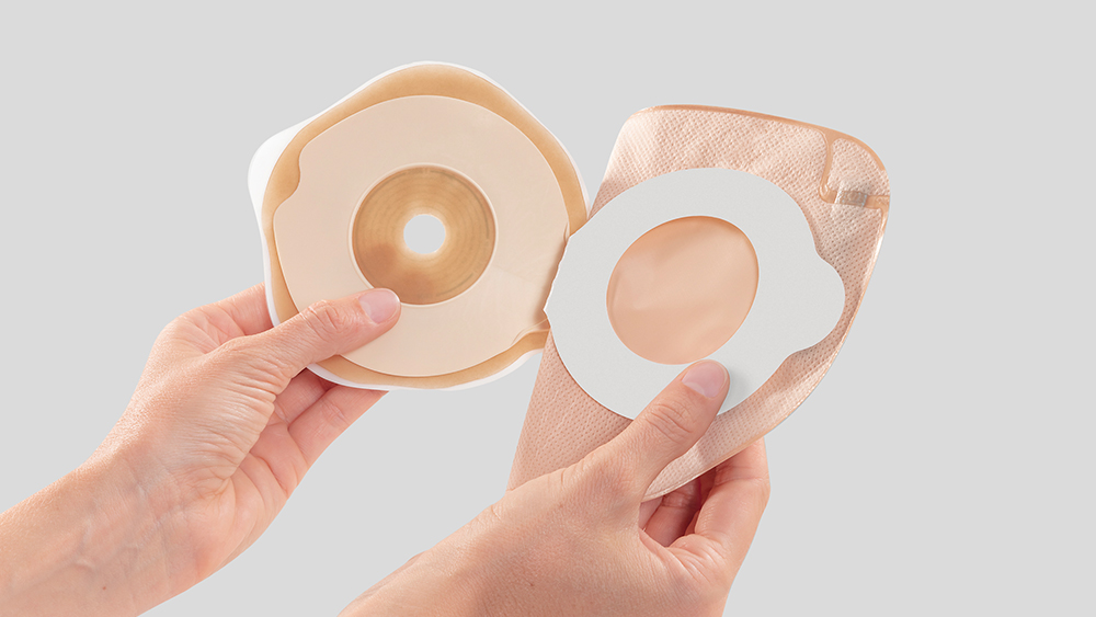 Két kéz egy flexima key zsákot tart, és kinyitja azt