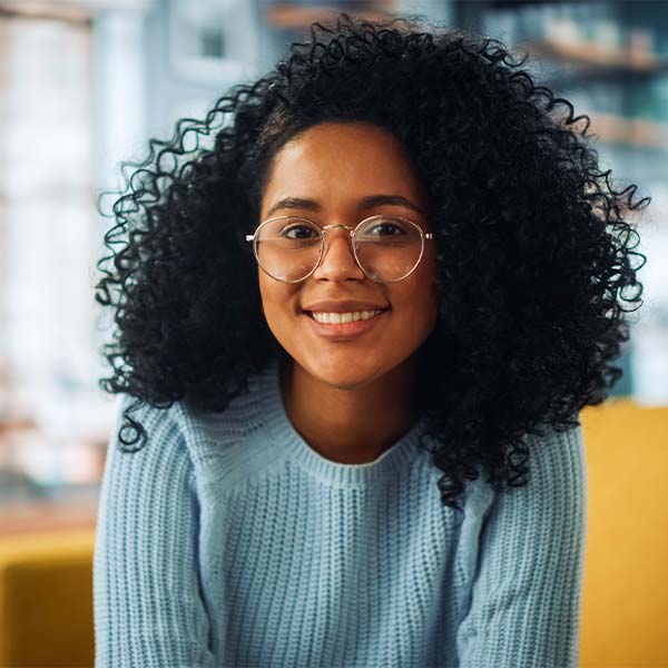 Szemüveget viselő egyén zöld háttér előtt, magabiztosságot és intelligenciát sugároz. 